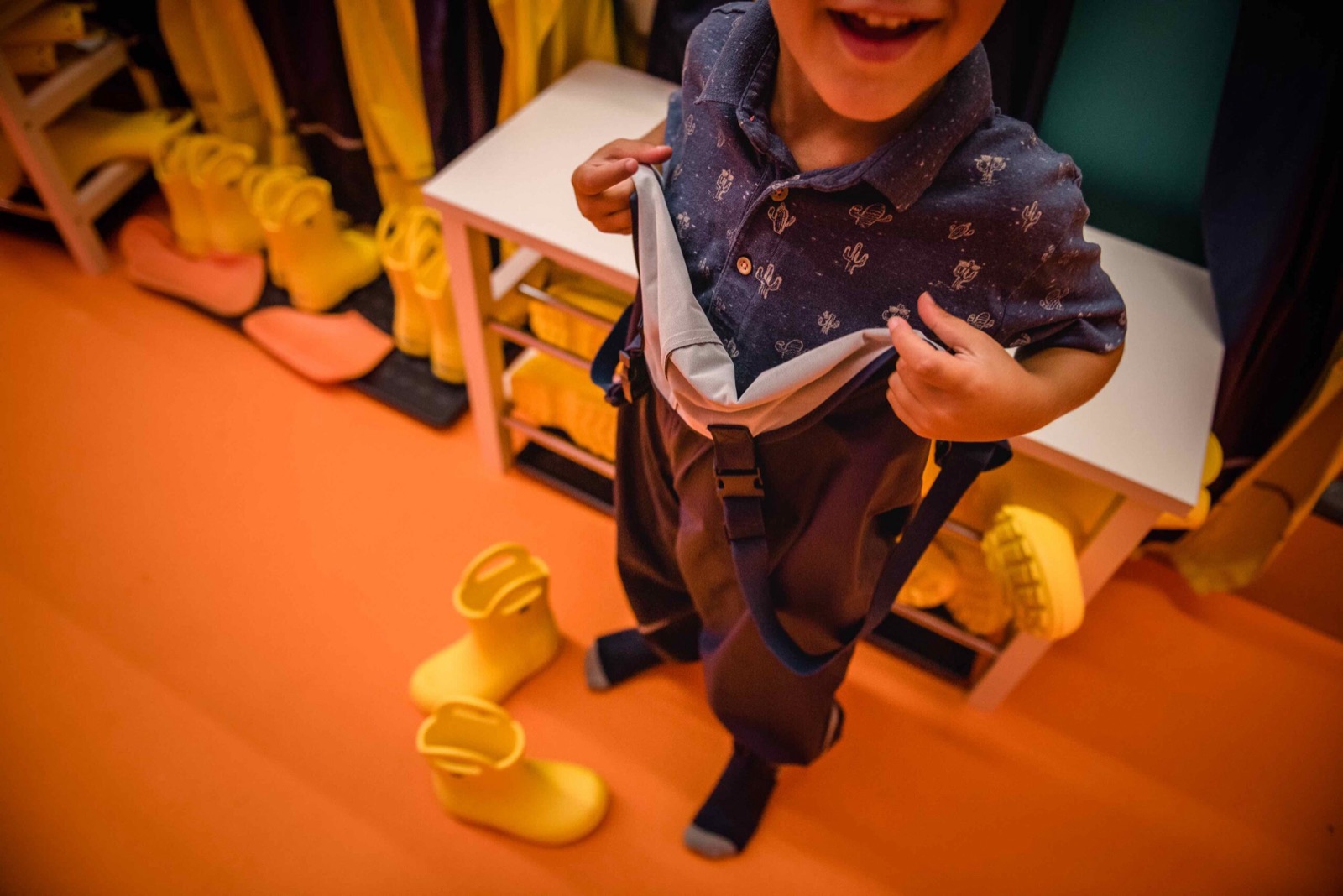 Bambino che indossa la salopette impermeabile
